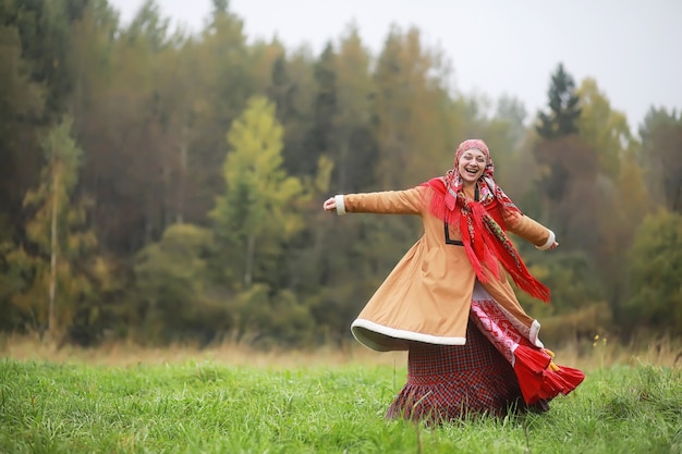 Tradycyjne słowiańskie obrzędy w stylu rustykalnym. Latem na zewnątrz. Gospodarstwo wiejskie słowiańskie. Chłopi w eleganckich szatach.