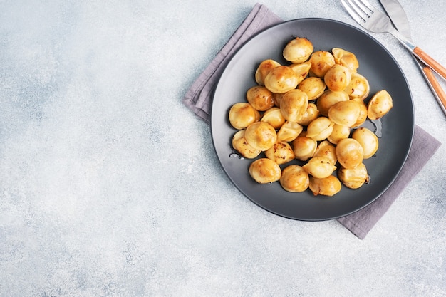 Tradycyjne smażone pelmeni, ravioli, pierogi z mięsem na czarnym talerzu, kuchnia rosyjska.