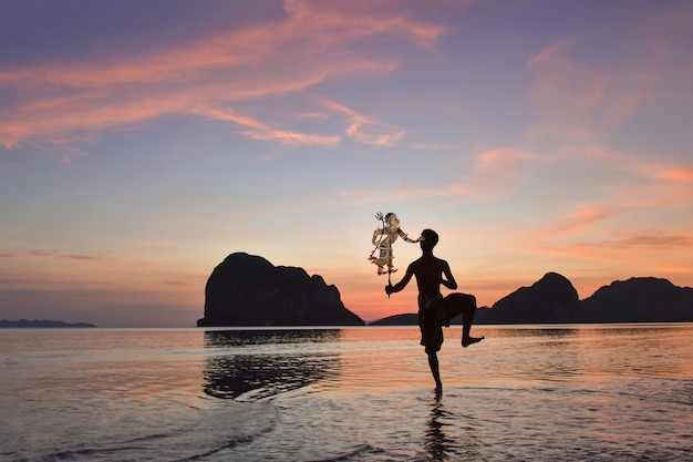 Tradycyjne Tajlandia Shadow Puppet Show na plaży podczas zachodu słońca, cienie lalek