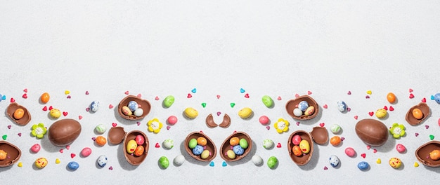 Tradycyjne wielkanocne słodycze z jajkami czekoladowy królik świąteczny jadalny wystrój Wyprawa dla dzieci modny twardy jasny ciemny cień Jasny kamień betonowe tło płaski format banera