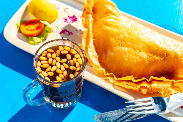Tradycyjne wypieki kuchni tunezyjskiej z mięsem Brik i herbata z orzeszkami piniowymi i miętą Widok z góry selektywny fokus