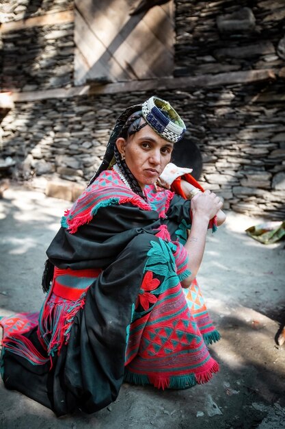 Zdjęcie tradycyjnie ubrana kobieta z plemienia kalash uśmiecha się w wiosce kalash valley w pakistanie