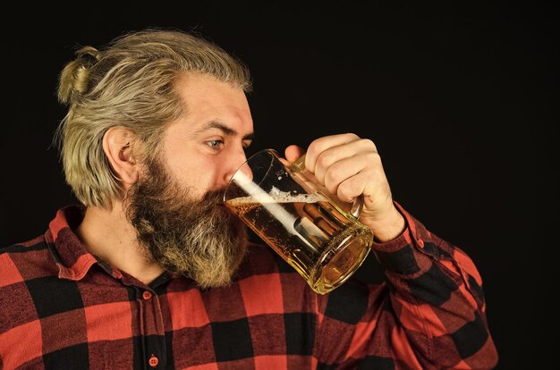 Zdjęcie tradycyjny bawarski mężczyzna cieszący się szklanką piwa w pubie oczekujący świeżego zimnego piwa lager po ciężkim dniu pracy pić piwo z beczki w barze przy barze zrelaksowany przystojny mężczyzna sącząc pyszne piwo