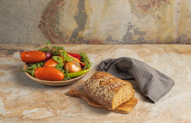 Tradycyjny drewniany talerz ze świeżymi warzywami sezonowymi zielona papryka pomidor cebula marchewka ogórek bazylia koper chleb