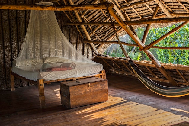 Tradycyjny hostel na świeżym powietrzu w stylu zanzibarskim z drewnianymi meblami, hamakiem i moskitierą