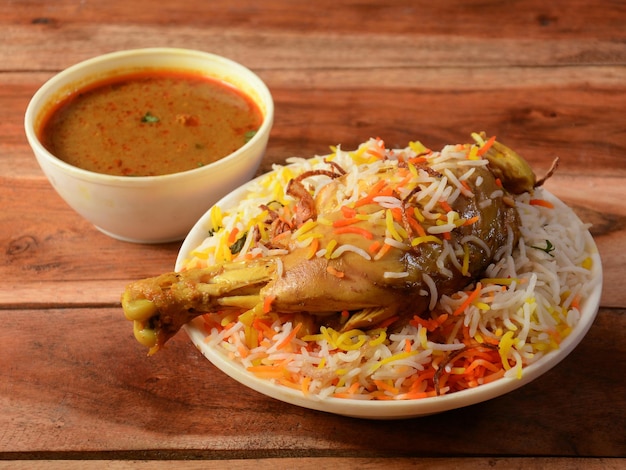 Tradycyjny Hyderabadi Chicken dum Biryani z ryżu Basmati gotowanego z przyprawami masala podawany z selektywnym skupieniem Salan