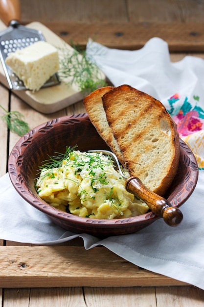 Tradycyjny omlet danie mołdawskie lub rumuńskie z serem, podawane z pieczywem na drewnianej powierzchni.