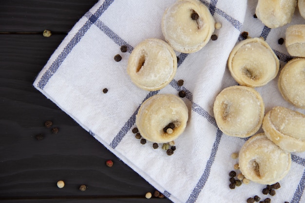 Tradycyjny Rosyjski Pelmeni Na Nieociosanym Drewnianym Stole. Domowe Pierogi. Półprodukty.