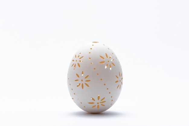 Tradycyjny rzeźbiący Easter jajko na białym tle. Rzeźbione jajko wielkanocne.
