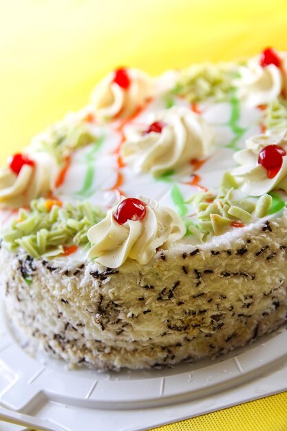 Tradycyjny słodki tort urodzinowy z kolorowymi świeczkami.