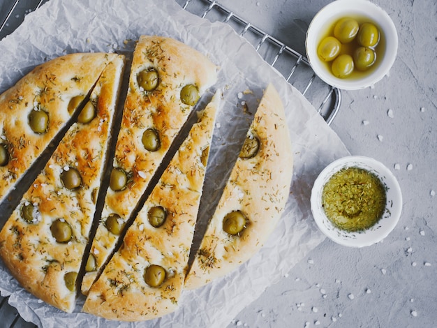 Tradycyjny włoski chleb focaccia z oliwkami, rozmarynem, solą i oliwą z oliwek