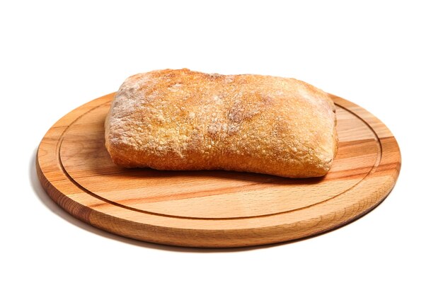 Tradycyjny włoski chleb pszenny ciabatta na drewnianej desce do krojenia. na białym tle