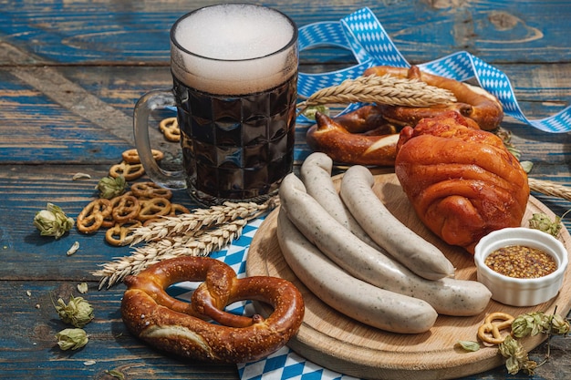 Tradycyjny zestaw na Oktoberfest Precle piwo weisswurst i eisbein z musztardą Niemiecka koncepcja jedzenia festiwalowego Modne twarde światło ciemny cień drewniane tło miejsce