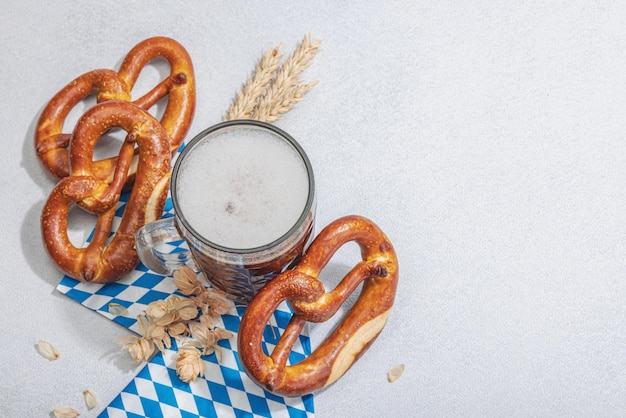 Zdjęcie tradycyjny zestaw oktoberfest precle i piwo koncepcja niemieckiego festiwalu żywności modne twarde światło ciemny cień jasny kamień betonowe tło widok z góry