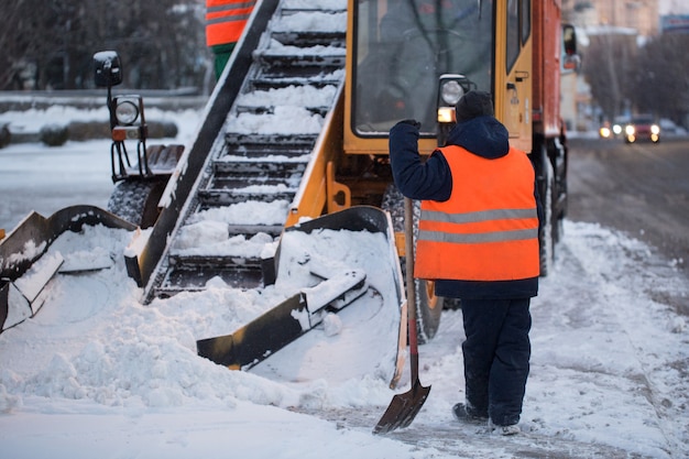 Traktor Oczyszczający Drogę Ze śniegu. Koparka Czyści Ulice Z Dużych Ilości śniegu W Mieście. Zimą Pracownicy Odśnieżają Drogi.