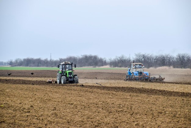 Traktor orze polem pługiem.