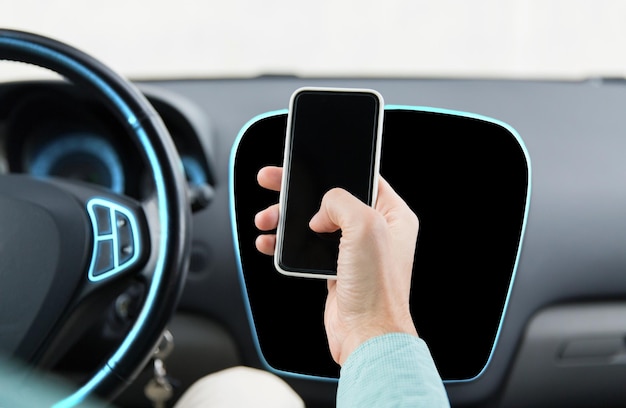 transport, podróż służbowa, koncepcja technologii i ludzi - zbliżenie męskiej dłoni ze smartfonem prowadzącym samochód