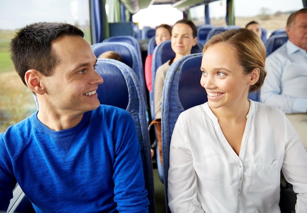 transport, turystyka, wycieczka samochodowa i koncepcja ludzi - grupa szczęśliwych pasażerów lub turystów w autobusie turystycznym