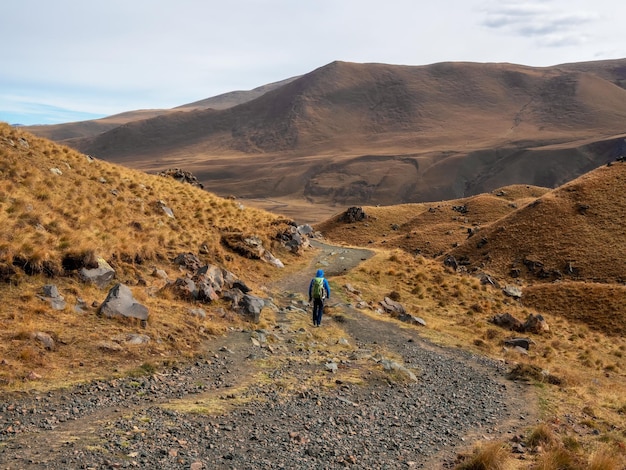 Trekking w górach Kaukazu Mężczyzna z plecakiem ciężko wspina się po górskim szlaku Przygoda podróżowanie w pojedynkę koncepcja stylu życia aktywny weekendowy urlop na dzikiej przyrodzie