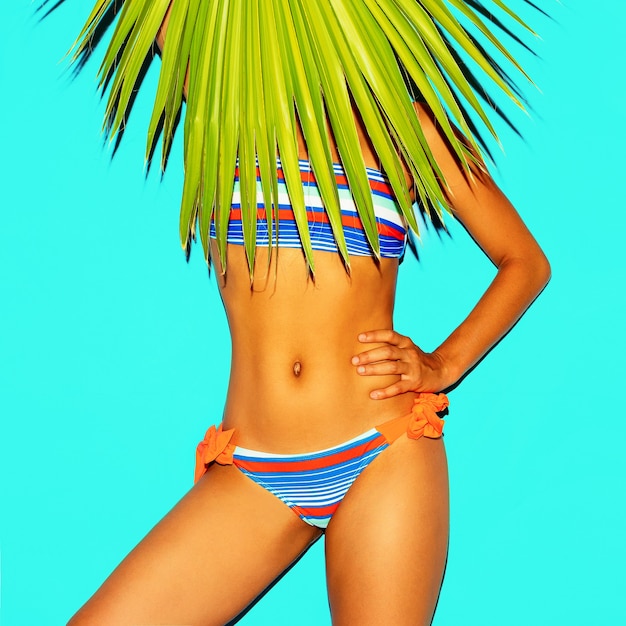 Trend w modzie plażowej. Liść palmowy. Kostium kąpielowy w paski. Minimalistyczny styl
