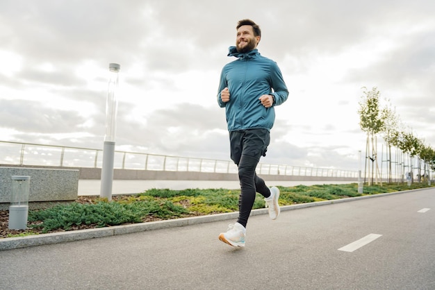 Trener fitness codziennie na świeżym powietrzu pełna długość mężczyzna rozgrzewka w buty do biegania prawidłowa technika