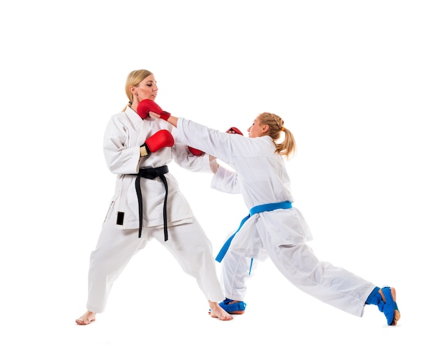 Trening bokserski dwóch młodych kobiet w białych kimonach i rękawicach bokserskich