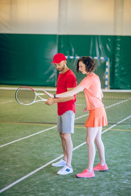 Trening. Mężczyzna W Czerwonej Czapce Z Rakietą Po Treningu Ze Swoim Trenerem