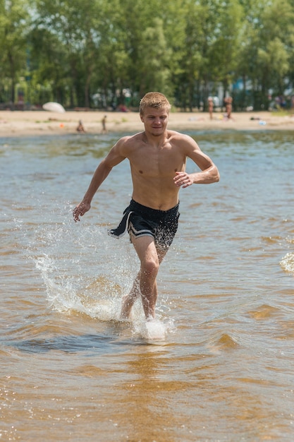 Trening młodego człowieka na plaży. Młody człowiek na poranny jogging