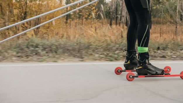 Trening sportowca na wrotkach Biathlon Jazda na nartorolkach z kijkami w kasku Jesienny trening Roller sport