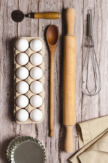 Zdjęcie trochę przyborów kuchennych i białych jajek na drewnianym stole