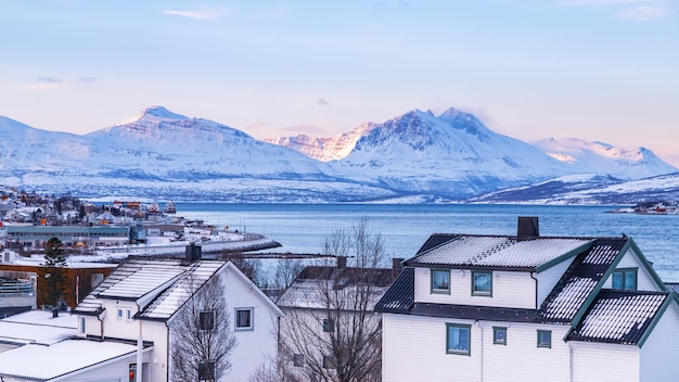 Tromso Norwegia Widok na arktyczne miasto z tradycyjnymi drewnianymi domami w zimowych ośnieżonych górach