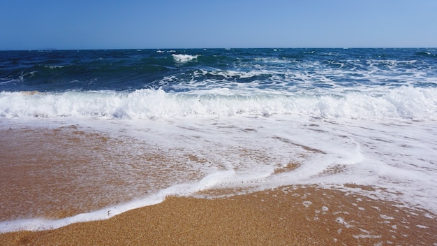 Tropikalna plaża. Tło fala oceanu. Piasek i błękitne morze. Natura wody oceanu, relaks na plaży. Letnie wakacje nad morzem