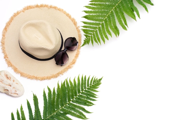 Tropikalne wakacje Słomkowa plaża sunhat okulary przeciwsłoneczne liść paproci na białym Widok z góry z miejsca na kopię Koncepcja lato