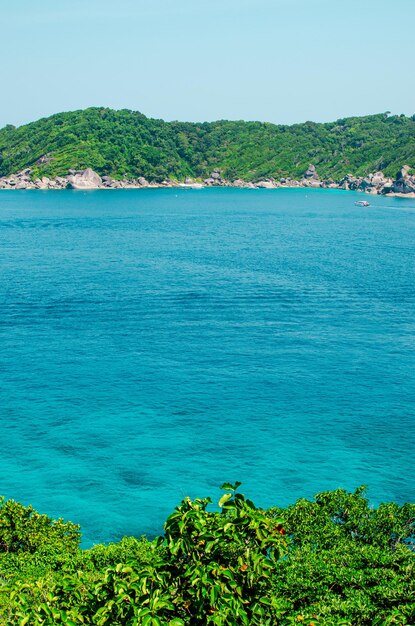 Zdjęcie tropikalne wyspy oceanu niebieskiej wody morskiej i białej piaskowej plaży na wyspach similan z słynną skałą żaglową phang nga krajobraz przyrody tajlandii