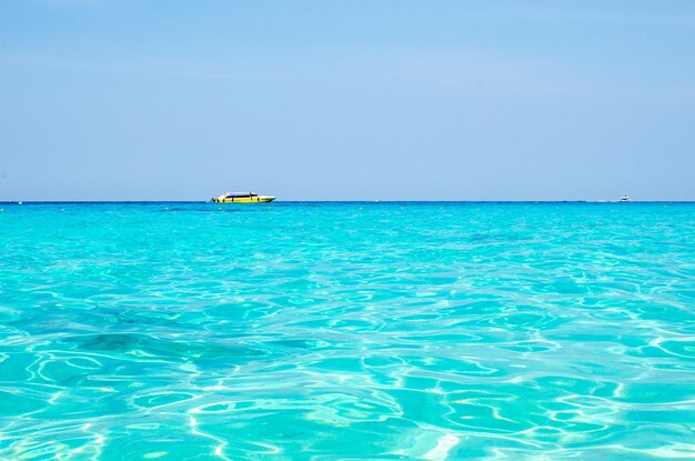 Zdjęcie tropikalne wyspy oceanu niebieskiej wody morskiej i białej piaskowej plaży na wyspach similan z słynną skałą żaglową phang nga krajobraz przyrody tajlandii