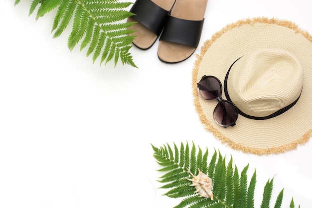 Tropikalny wzór wakacje Słomkowa plaża kapelusz przeciwsłoneczny okulary przeciwsłoneczne plaża uderza liść paproci na białym Widok z góry z miejscem na kopię Lato