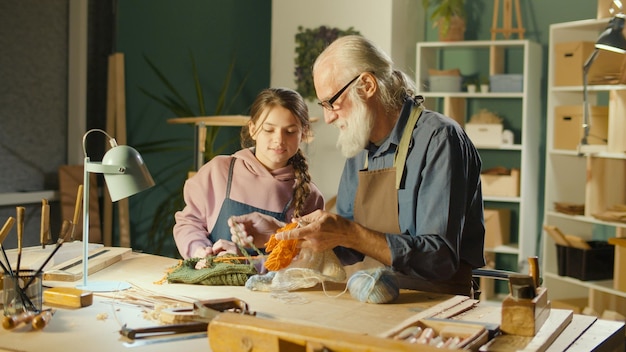 Zdjęcie troskliwy dziadek ze swoją nastoletnią wnuczką spędzają razem czas hobby