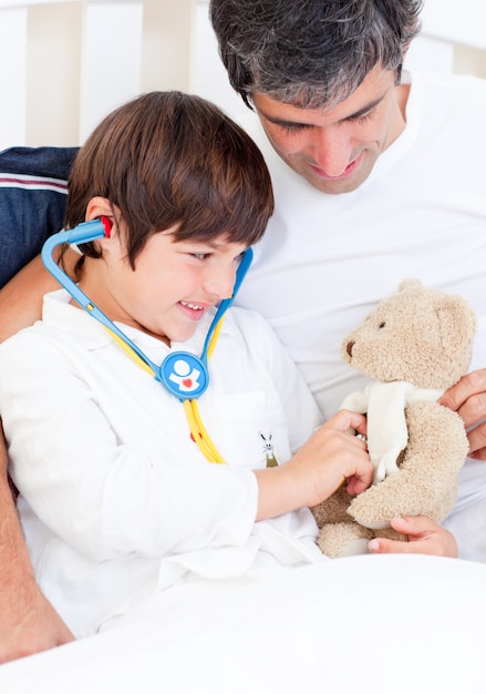 Troskliwy ojciec i jego chory syn bawić się z stetoskopem