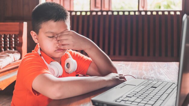 Trudności z edukacją domową lub nauką online z przygnębionym azjatyckim chłopcem