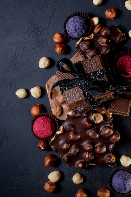 Trufla czekoladowa z kawałkami czekolady i latającym kakao w proszku na ciemnej powierzchni.