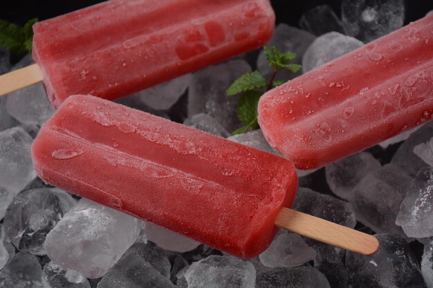 Zdjęcie truskawkowy popsicle na niebieskim tle