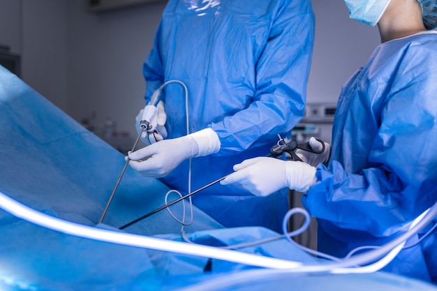 Trzech chirurgów wykonujących operację laparoskopową Lekarze patrzący na obraz na monitorze Koncepcja medycyny i opieki zdrowotnej Narząd wewnętrzny pacjenta widziany na monitorze komputera