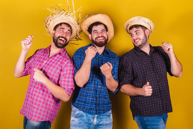 Trzech przyjaciół ubranych w typowe stroje na imprezę Festa Junina Dancing