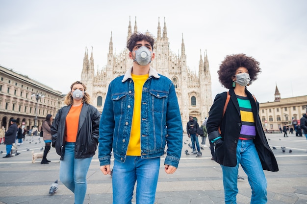 Trzech wieloetnicznych przyjaciół noszących maski medyczne chroniące przed zanieczyszczeniem i wirusami