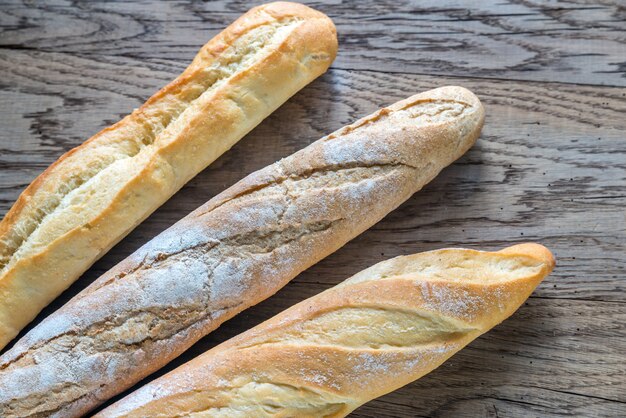 Trzy baguettes na drewnianym tle