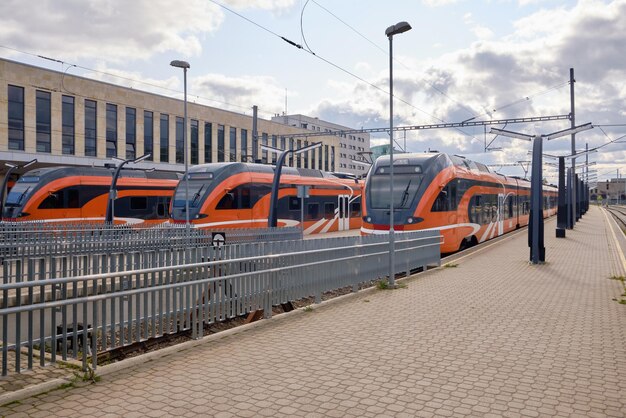 Trzy czerwone nowoczesne pociągi na głównym dworcu w Tallinie Estonia