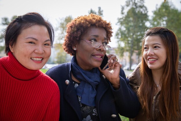 Trzy dojrzałe kobiety razem w parkowej przyjaźni między ludźmi różnych narodowości