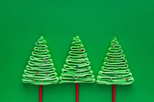 Zdjęcie trzy drzewa bezowe w stylu noworocznym na zielonym tle.
