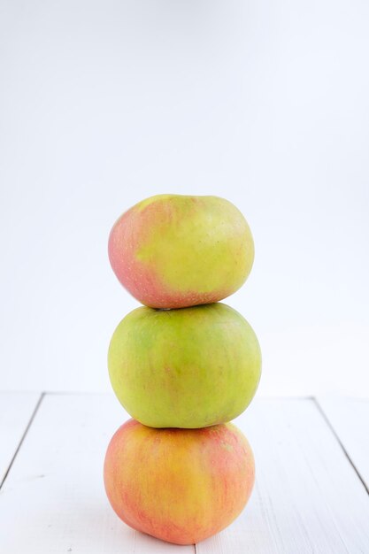 Trzy jabłka ułożone na białym tle z miejsca na kopię