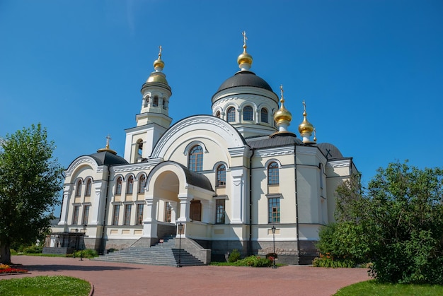 Trzy kopuły z krzyżami, jedna złota i dwie zielone błękitnego nieba cerkwi
